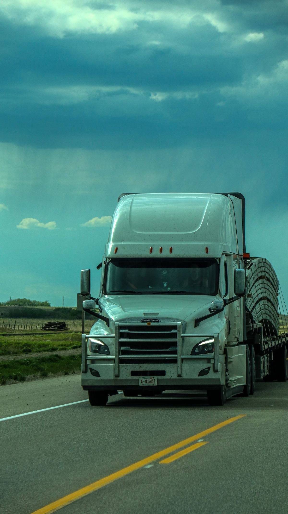Freight truck hauling a flatbed load on the highway